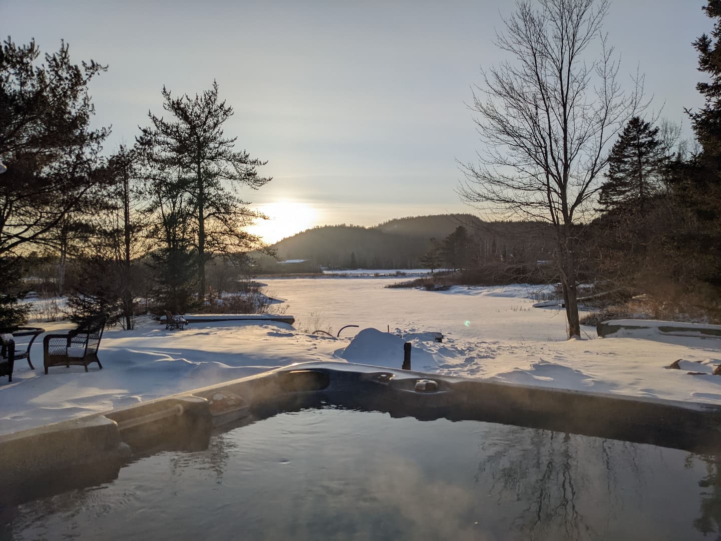 Hot tub overlooking the frozen lake at sunrise